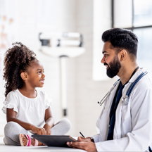Young pediatrician talks with patient.